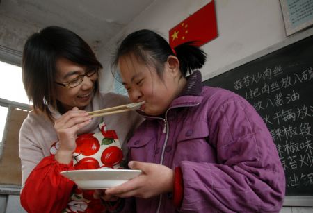 A student tastes a dumpling made by herself at Xingtai Special Education School in Xingtai of north China&apos;s Hebei Province, Dec. 22, 2009.(Xinhua/Huang Tao)