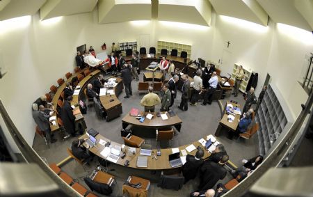 Accused Nazi death camp guard John Demjanjuk (L, top) is brought in a courtroom in Munich December 22, 2009. The trial of Demjanjuk, an 89-year-old former U.S. auto worker, facing charges he helped force 27,900 Jews into gas chambers in Sobibor extermination camp in 1943, resumed on Monday. 