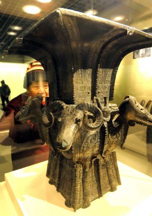 A visitor views an exhibit during the national treasure exhibition, organized by the National Museum of China, in Hangzhou, capital of east China&apos;s Zhejiang Province, Dec. 22, 2009. The exhibition was opened on Tuesday, displaying 80 cultural relics. (Xinhua/Zhu Yinwei)