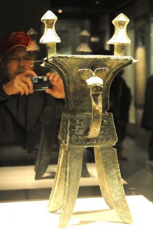 A visitor takes photos of an exhibit during the national treasure exhibition, organized by the National Museum of China, in Hangzhou, capital of east China&apos;s Zhejiang Province, Dec. 22, 2009.(Xinhua/Zhu Yinwei)