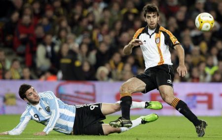 Argentina&apos;s Gonzalo Higuain (L) tries to kick the ball against Catalunya&apos;s Oleguer Presas during a friendly soccer match at Camp Nou stadium in Barcelona December 22, 2009.