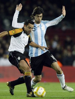 Argentina&apos;s Javier Pastore (R) fights for the ball with Catalunya&apos;s Xavi Hernandez during a friendly soccer match at Camp Nou stadium in Barcelona December 22, 2009.