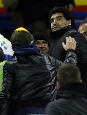 Argentina&apos;s coach Diego Armando Maradona is stopped by a supporter during a friendly soccer match against Catalunya at Camp Nou stadium in Barcelona December 22, 2009. 