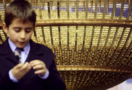 A schoolboy reads the number on a lottery ball during the world