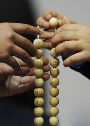 School children place lottery balls with the winning numbers (R) and corresponding prize money (L) in two columns during the world