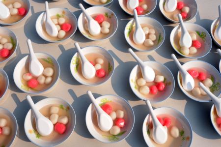 Photo taken on Dec. 22, 2009 shows bowls of colorful sweet dumplings made by several thousand teachers, students and students&apos; parents at a middle school in Taipei, southeast China&apos;s Taiwan. People gather on campus of the school to observe a traditional custom of making sweet dumplings at the Winter Solstice.