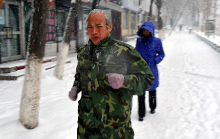 A man runs in the snow in Urumqi, capital of northwest China&apos;s Xinjiang Uygur Autonomous Region, Dec. 23. 2009. The temprature in some parts of the autonomous region fell to 40 degreeds below zero due to the affection of the strong old air blowing from Siberia.