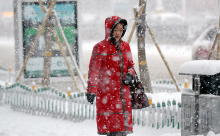 A woman walks in the snow in Urumqi, capital of northwest China&apos;s Xinjiang Uygur Autonomous Region, Dec. 23. 2009. The temprature in some parts of the autonomous region fell to 40 degreeds below zero due to the affection of the strong old air blowing from Siberia.