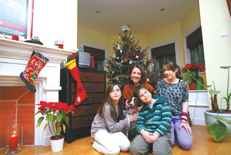 Marie Finn (second from left) and her children in their home. [Guan Xin/China Daily]