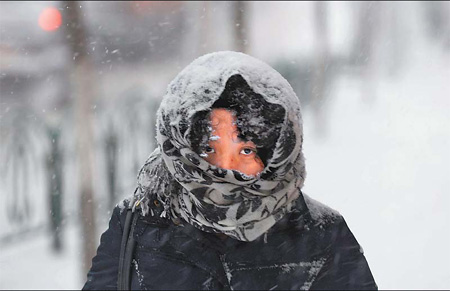  A woman walks in heavy snow in Urumqi, capital of the Xinjiang Uygur autonomous region, yesterday. [China Daily]