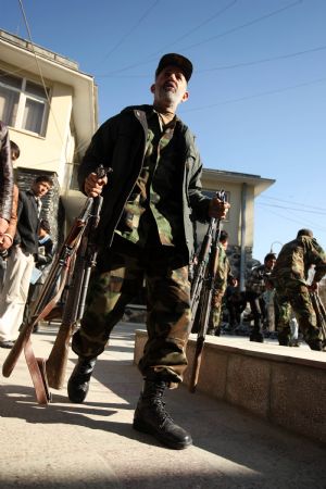 An Afghan officer carries AK-47 rifles during a handover ceremony in the Afghan capital Kabul, Dec. 23, 2009. Afghan anti-terrorism department handed over 85 AK-47 rifles and ammunition to the Disarmament of Illegal Armed Groups (DIAG) on Wednesday. The weapons were seized from illegal armed groups. (Xinhua/Zabi Tamanna)