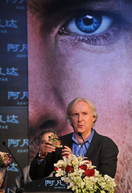 Canadian film director James Cameron shows a gift presented by China Film Group Corporation during a press conference to promote his latest film "Avatar" in Beijing, capital of China, on Dec. 23, 2009. "Avatar" is the story of an ex-Marine who finds himself thrust into hostilities on an alien planet filled with exotic life forms. The film is scheduled to debut on Jan. 4, 2010 in China. (Xinhua/Jin Liangkuai) 
