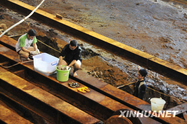 Archeologists work on the 800-year-old Nanhai No. 1 merchant ship Thursday. [Zhou Qiang/Xinhua]
