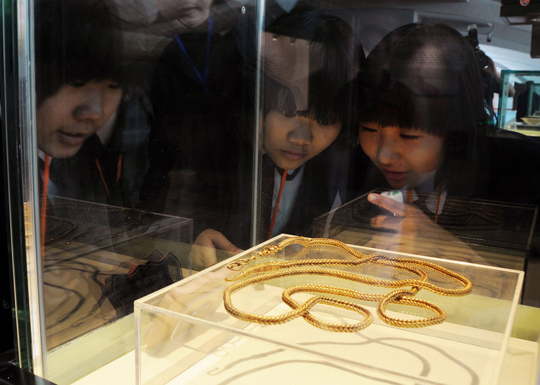 A visitor examines a relic from the Nanhai No. 1 merchant at its opening Thursday. [Liang Wendong/Chinanews]