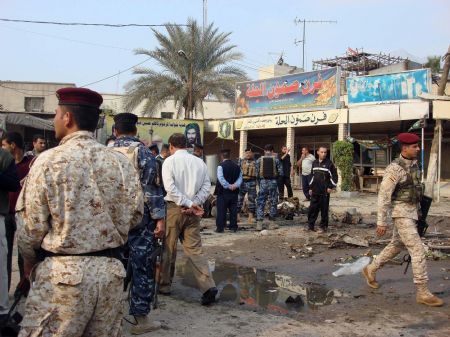 Iraqi security personnel patrol the site of bomb attacks in Hilla, 100 km (62 miles) south of Baghdad, December 24, 2009. At least nine people were killed and some 70 injured on Thursday in a bomb and a car bomb explosions in central the city of Hilla, the capital of Babel province south of Baghdad.(Xinhua/Reuters Photo)