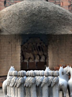 Unfinished archaized craftworks are seen in front of a clay stove at a workshop in Nanshishan Village, Mengjin County of central China&apos;s Henan Province, Dec. 24, 2009.(Xinhua/Wang Song)