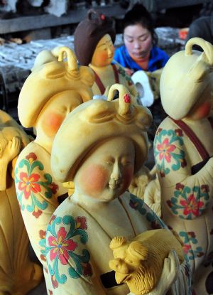 A worker paints a three-color glazed figurine at a workshop in Nanshishan Village, Mengjin County of central China&apos;s Henan Province, Dec. 24, 2009.(Xinhua/Wang Song)