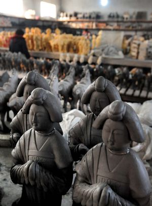 Unfinished archaized craftworks are seen at the corner of a workshop in Nanshishan Village, Mengjin County of central China&apos;s Henan Province, Dec. 24, 2009.(Xinhua/Wang Song)