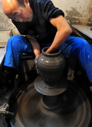 A man works on an archaized craftwork at a workshop in Nanshishan Village, Mengjin County of central China&apos;s Henan Province, Dec. 24, 2009.(Xinhua/Wang Song)