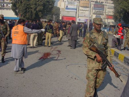 Security personnel keep guard at the site of a suicide bombing in the northwestern Pakistani city of Peshawar, on Dec. 24, 2009. At least four people were killed and 11 others injured on Thursday in a suicide bombing in Peshawar, according to local TV reports. (Xinhua/Saeed Ahmad) 