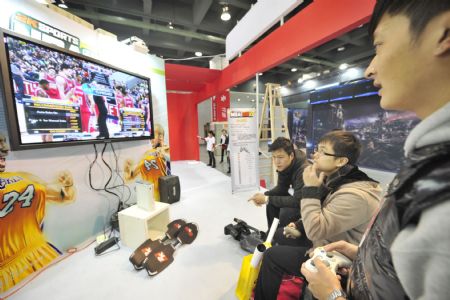  Visitors try a digital game on the WMG3 Digital Game Expo in the Zhejiang World Trade International Center in Hangzhou, east China&apos;s Zhejiang Province, Dec. 24, 2009. The expo lasts from Dec. 24 to 27 with mainstream game products with digital interactive entertainment technologies. (Xinhua/Li Zhong)