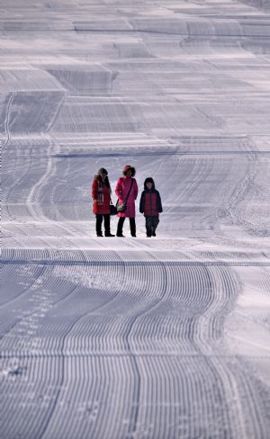 Tourists walk on a skiing track in Yakeshi, north China&apos;s Inner Mongolia Autonomous Region, Dec. 22, 2009.(Xinhua/Li Xin)