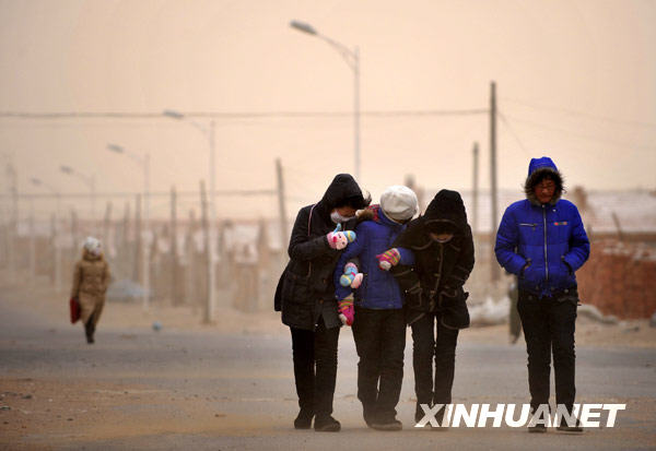 Pedestrians walk against strong wind on the street in Abagaqi prefecture in north China's Inner Mongolia Autonomous Region on Thursday, December 24, 2009. [Xinhua] 