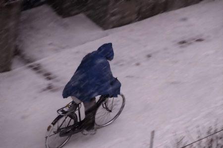 A local citizen rides bicycle against wind and snow in Dalian, northeast China&apos;s Liaoning Province, Dec. 25, 2009. A strong cold wave and heavy snowfall hit Liaoning Province from Thursday night, causing a sudden temperature fall of over ten degrees Celsius. [Wang Xizeng/Xinhua]
