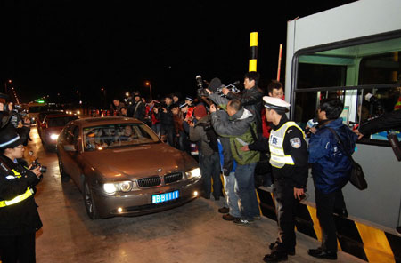 A car runs past Shuangqiao toll gate of the Zhoushan Sea-crossing Bridge in Zhoushan, east China's Zhejiang Province, Dec. 25, 2009.