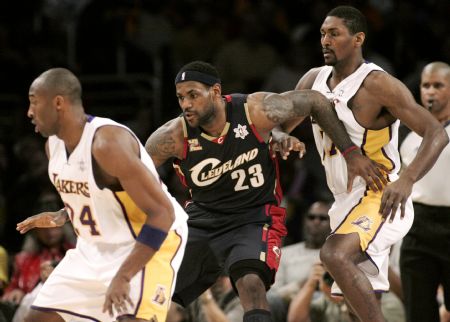 Cleveland Cavaliers LeBron James (C) moves into position for a pass as Los Angeles Lakers Kobe Bryant (L) and Ron Artest defend during the first quarter of their NBA basketball game in Los Angeles December 25, 2009.