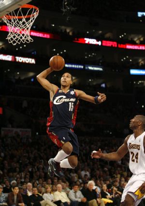 Cleveland Cavaliers' Jamario Moon (L) dunks the ball as Los Angeles Lakers' Kobe Bryant looks on during the first half of their NBA basketball game in Los Angeles, December 25, 2009.