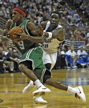 Boston Celtics guard Rajon Rondo (L) drives past Orlando Magic forward Mickael Pietrus during first half NBA basketball action in Orlando, Florida December 25, 2009.