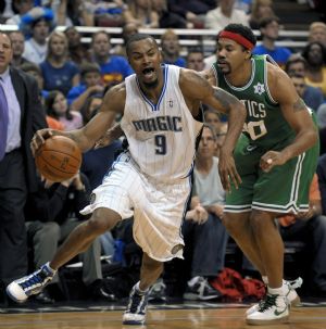 Boston Celtics guard Rajon Rondo (L) drives past Orlando Magic forward Mickael Pietrus during first half NBA basketball action in Orlando, Florida December 25, 2009.