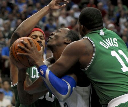 Orlando Magic center Dwight Howard (C) is double teamed by Boston Celtics forwards Rasheed Wallace and fouled by Glen Davis (R) during second half NBA basketball action in Orlando, Florida December 25, 2009.