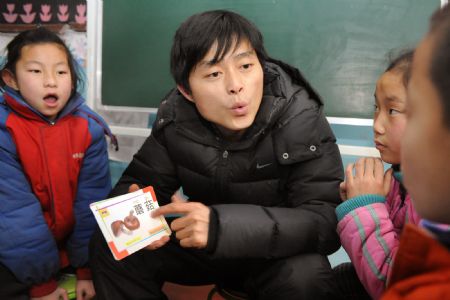  A teacher talks to students with special difficulties on speaking at a special education school in Shenmu County, northwest China's Shaanxi Province, Dec. 23, 2009. What the coal-rich county with 400,000 people offers is not only free medical service to its people, but also 12 years of free education for all children, better housing for farmers and urban poor, and poverty relief. (Xinhua/Tao Ming)