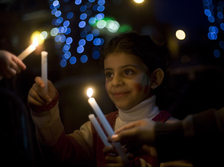 A Palestinian girl takes part in a candle-lighting protest in solidarity with Gaza, in the West Bank city of Ramallah, on Dec. 27, 2009. Palestinians on Sunday held a protest against the Israeli offensive on Gaza Strip which killed more than 1,400 Palestinians on Dec. 27, 2008. Dec. 27, 2009 is the first anniversary of the Israeli offensive on Gaza Strip. (Xinhua/Fadi Arouri)