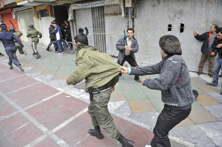 An Iranian opposition supporter holds a policeman during clashes in central Tehran December 27, 2009.