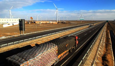 A truck runs by the wind power base in Jiuquan of northwest China's Gansu Province in this Nov. 30, 2009 picture. 