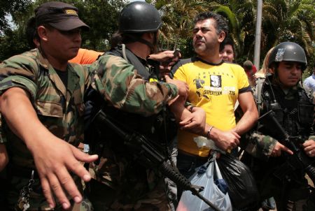 Policemen escort drug dealer Jarvis Chimenes Pavao (C) to custody in Asuncion, capital of Paraguay, Dec. 27, 2009.