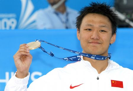 Zhang Lin shows the gold medal after the men&apos;s 800m freestyle swimming final at the World Championships in Rome, Italy, July 29, 2009.(Xinhua File Photo)