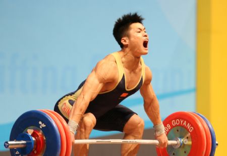 Lu Xiaojun of China takes a lift during the the men&apos;s weightlifting 77kg at the world weightlifting championships in Gaoyang of Guangdong Province,China, Nov. 24, 2009.(Xinhua File Photo)