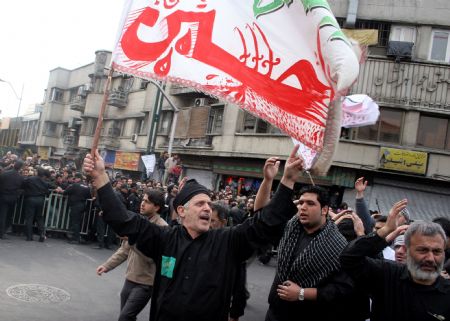 People wave flags during an Ashura procession on the final day of Ashura in Tehran, capital of Iran, Dec. 27, 2009. Dec. 27, 2009. 