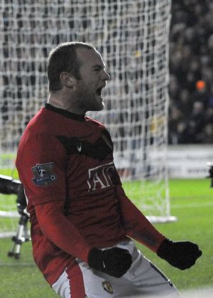 Manchester United's Wayne Rooney celebrates after his shot was deflected into goal by Hull City's Andy Dawson during their English Premier League soccer match in Hull, northern England December 27, 2009. 