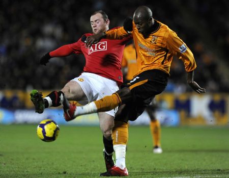 Hull City's Anthony Gardner (R) challenges Manchester United's Wayne Rooney during their English Premier League soccer match in Hull, northern England December 27, 2009.