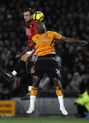 Hull City's Kamil Zayatte (R) challenges Manchester United's Dimitar Berbatov during their English Premier League soccer match in Hull, northern England December 27, 2009.