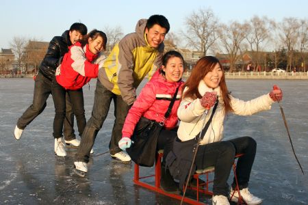 A group of young people enjoy skating on the ice at the Zizhuyuan Park in Beijing, Dec. 27, 2009. Citizens swarmed to enjoy the funs of outdoor activity for the winter pleasure in Beijing, as the temperatures kept on lowering.