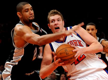 David Lee of New York Knicks is defended by Tim Duncan of San Antonio Spurs (L) during their NBA games in New York, the United States, Dec. 27, 2009. San Antonio Spurs won the match 95-88.