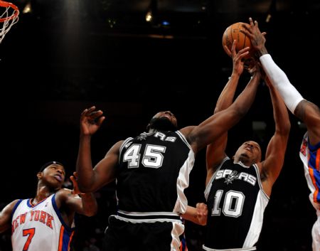 Dejuan Blair (L2) of San Antonio Spurs and his teammate Keith Bogans (L3) grab the rebound during their NBA games against New York Knicks in New York, the United States, Dec. 27, 2009. San Antonio Spurs won the match 95-88.