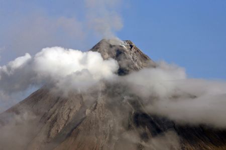 Clouds partially covers Mayon volcano' s crater as seen in Legazpi City, Albay province, south of Manila December 28, 2009. Philippine government's vulcanologists officials said on Sunday, Mayon volcano has been calmed over the weekend but warned the public not to be complacent because there could be an explosive eruption soon due to clogging of magma inside and the swelling of its surface.