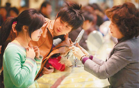 A couple selects gold products at Caibai Store yesterday. Gold rings and necklaces are popular New Year gifts among local people. Mirror Evening News
